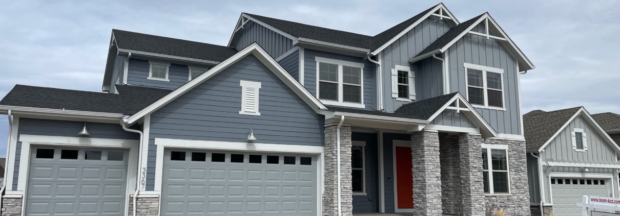 Two-story home for sale in the Denver metro with RE/MAX listing sign in the front yard